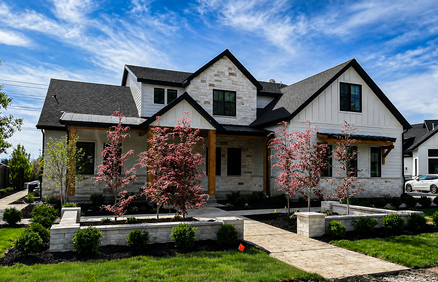 Walkways & Entryways in Utah White farmhouse with stone accents, a paver front walkway and stone retaining walls, walkways & entryways by Empire Pavers in Utah