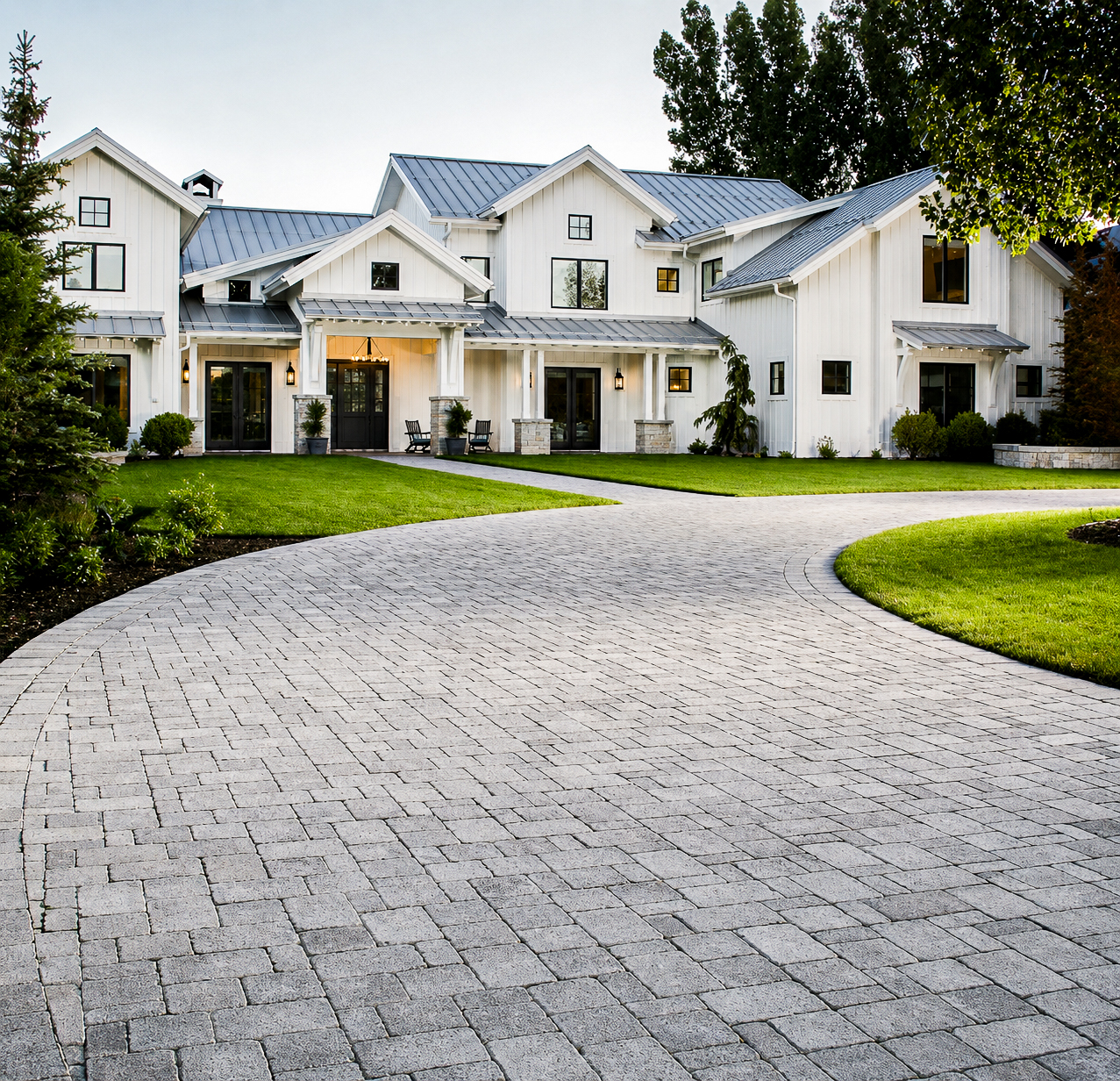 Commercial Paver Installation in Utah Grey paver driveway curving up to a white modern farmhouse in Utah, commercial paver installation by Empire Pavers in Utah